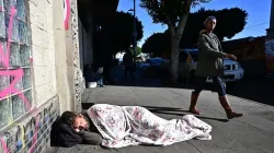Un sans-abri dort sur le trottoir dans le centre de Los Angeles le 22 novembre 2023. / 