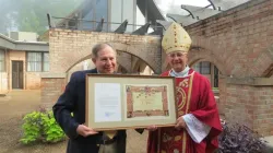 Mgr Steven Raica, évêque de Birmingham, Alabama, a remis au vice-président de la théologie d'EWTN, Colin Donovan, la lettre de nomination et le diplôme de l'Académie pontificale mariale internationale au cours d'une messe le 9 août. | / 