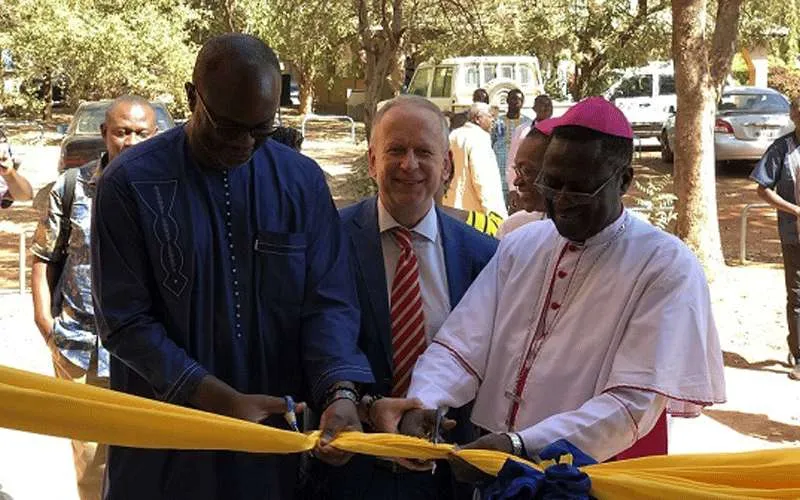 Mgr Alexandre Yikyi Bazié (à droite), l'Ambassadeur Ingo Herbert (au centre) et Adegbola Fasutin Adeye (à gauche) coupant le ruban d'inauguration du nouveau siège du CJP-Burkina à Ouagadougou le mardi 3 décembre 2019 - CJP-Burkina