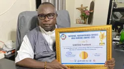 Le père Peter Konteh avec le prix reçu par Caritas Freetown lors de la commémoration de la Journée mondiale de l'aide humanitaire le 19 août. / Caritas Freetown