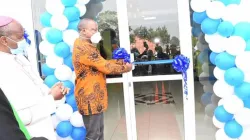 Le secrétaire du cabinet de la santé du Kenya, Mutahi Kagwe, coupe la bande à l'hôpital de la mission de Kiriaini, marquant ainsi l'ouverture de sa nouvelle aile ultramoderne pour les patients externes. Mgr James Maria Wainaina est présent. / Domaine public