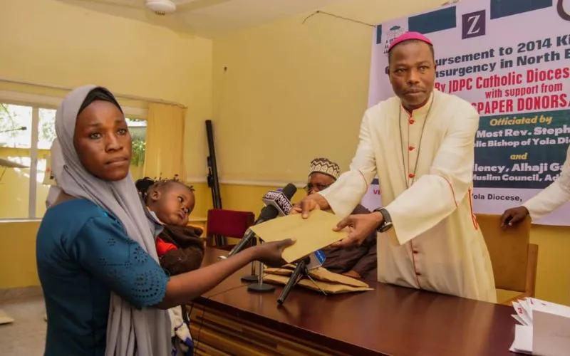 Mgr Stephen Dami Mamza remettant la somme de 150 000 Naira à l'une des victimes de l'insurrection de Boko Haram. Crédit : Diocèse de Yola / 