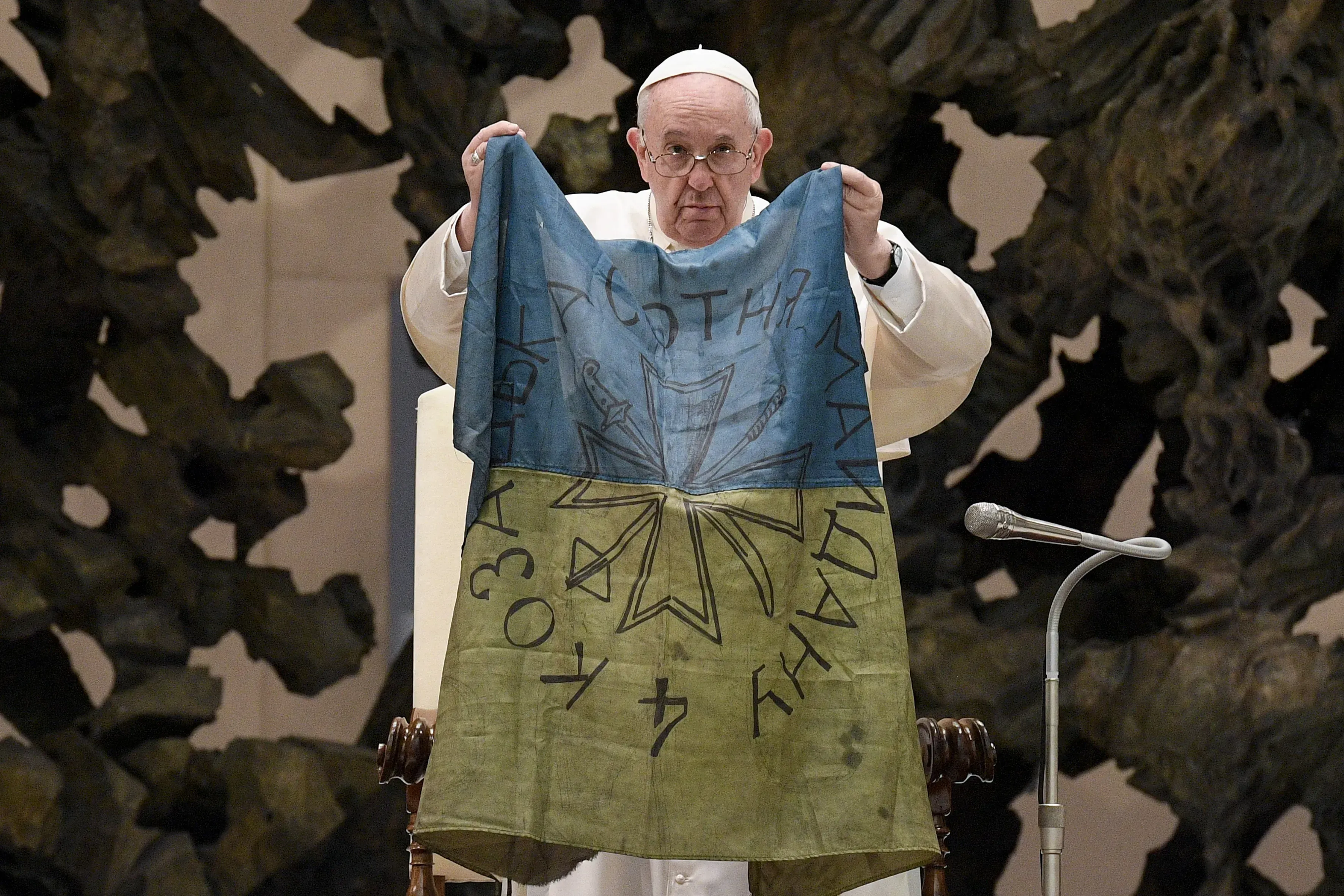 Le pape François brandit un drapeau qui, selon lui, lui a été apporté de "la ville martyre" de Buca, en Ukraine, lors de son audience générale du 6 avril 2022. Vatican Media / 