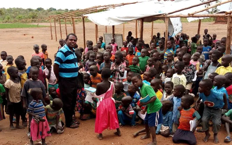 Le père Lazar Arasu, directeur du service des réfugiés de Don Bosco Palabek, avec des écoliers au camp de réfugiés de Palabek. Don Bosco Palabek Refugee Services