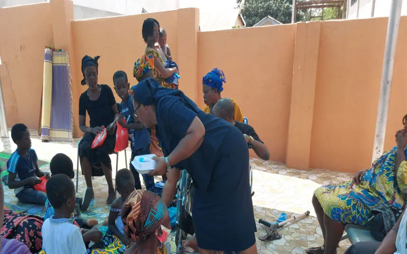 Sr Olivia Umoh, DC, directrice de Safe-Child Advocacy (SCA), une organisation humanitaire appartenant à l'archidiocèse de Kumasi, partageant de la nourriture avec des enfants handicapés et leurs mères lors d'une récente fête pour les personnes vulnérables. SCA.