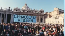 La communauté de la Maison de Marie pose pour une photo le 8 décembre 1994, sur la place Saint-Pierre, la première fois qu'ils ont apporté leur bannière bleue avec les mots "L'Immaculée Conception triomphera" à l'Angélus avec le Pape Jean-Paul II. Le groupe a continué à apporter la bannière à l'Angélus chaque dimanche pendant 29 ans. | Crédit : Comunita Casa di Maria / 