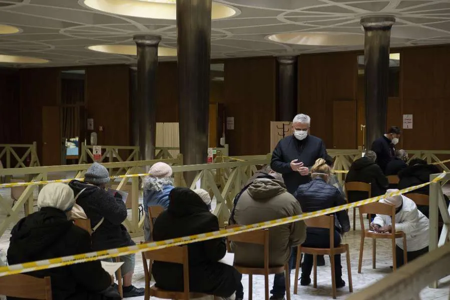 Le cardinal Konrad Krajewski, avec des sans-abri attendant d'être vaccinés dans l'atrium de la salle Paul VI au Vatican, le 20 janvier 2021. Vatican Media.