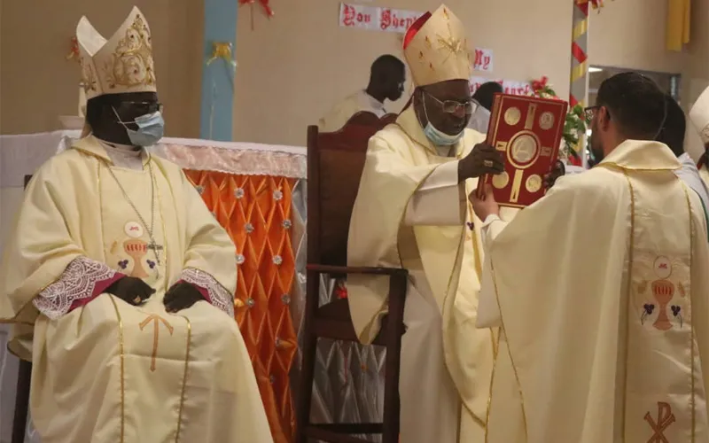 Mgr Carlassare reçoit la Sainte Bible des mains du cardinal Gabriel Zubeir Wako lors de l'ordination épiscopale du 25 mars qui s'est tenue à la cathédrale Saint-Père du diocèse de Rumbek. Crédit : P. Wanyonyi Eric Simiyu, S.J. (Rumbek)