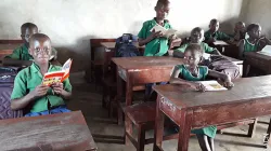 Les enfants de la paroisse Sainte Thérèse de l'Enfant Jésus à Bo, Sierra Leone en train de lire la Bible de l'enfant, "Dieu parle à ses enfants". / Aide à l'Église en détresse (AED).