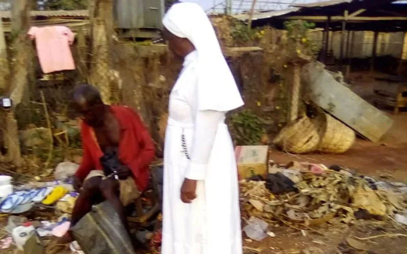 Sr Esther Nkiru Ezedinachi s'arrête pour échanger des civilités avec un homme handicapé mental dans les rues de l'État d'Anambra au Nigeria. Crédit : Sr Esther Nkiru Ezedinachi