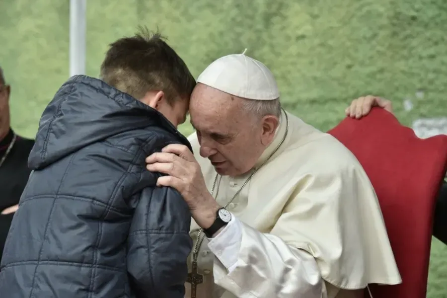 Le pape François écoute un garçon appelé Emanuele à la paroisse Saint-Paul de la Croix, à Rome, le 15 avril 2018. Vatican Media